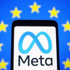 Metan logo puhelimen näytöllä, taustalla Euroopan union lippu. 