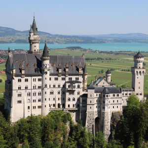 Slottet Neuschwanstein står på ett berg framför Schwangau och sjön Forggensee.
