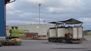 Via Lovisa hamn exporteras bland annat trävaror en lastbil som nästan är avlastad av en liten blå truck