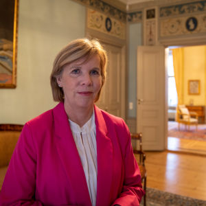 Anna-Maja Henriksson står på finska ambassadörens residens i Stockholm 30.1.2024. I bakgrunden hänger ett porträtt på Mannerheim.
