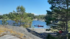 Att ta kajaken till jobbet är för Charlotta Berlin att kunna njuta av att vara en del av naturen. En röd kajak kommer till en klippig strand.