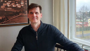 Gruppturism är förbi för den här säsongen, anser Henrik Forsblom. En man sitter bakom ett köksbord och tittar in i kameran.