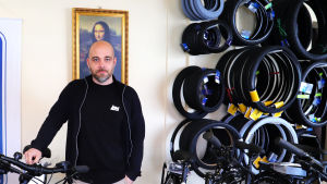 Matti Hätinen har redan sålt cirka 150 cyklar i år. Matti Hätinen framför en Mona Lisa- tavla i en cykelaffär.
