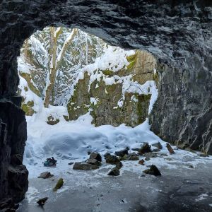 Grottor och underjord är del av Finntrolls textuniversum. Grottmynning, snömassor och is. Soligt väder.
