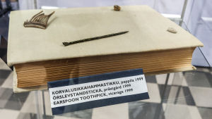 Örslevsstickan tillsammans med bland annat en bit av en kam och en bit av en tandborste. Örslevsstickan har hittats i arkeologiska utgrävningar vid prästgården i Pernå kyrkoby. Flera små fynd utanpå en bok i en glasmonter. Närmast kameran syns en örslev, ett avlångt litet metallföremål med slevformad ända.