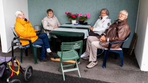 Här, i lä under en balkong, träffas Ros-Marie Wikström, Ruth Jussila, Christina Larinmäki och Sven Backman. Ros-Marie Wikström, Ruth Jussila, Christina Larinmäki och Sven Backman vid utesittgruppen.