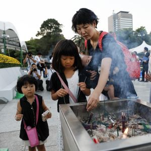 Hiroshimabor tände rökelse vid minnesmärket till offren, strax innan ceremonin inleddes på söndagen. 