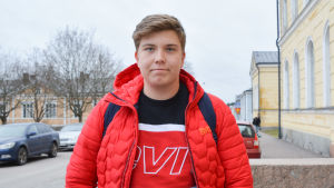 Wille Grönman är 17 år och kan tänka sig en framtid som företagare. Tonåring i röd jacka utanför skola.