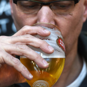 En man dricker öl.