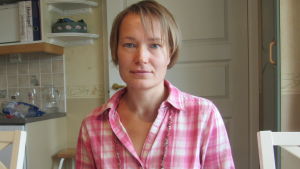 Linda Karlström sitter vid ett bord.