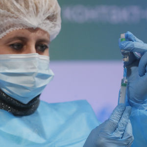 Vaccineringen har inte kommit igång tillräckligt. En sjukskötare i Ukraina håller i ett coronavaccin.