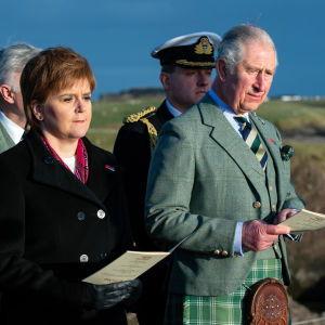 Prins Charles och Skottlands förstaminister Nicola Sturgeon ser allvarliga ut vid en utomhusceremoni. Charles är klädd i kilt.