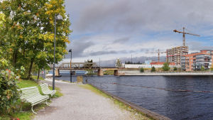 Ingen egen bild från den här stranden… Jag iddes inte smygfotografera folk i baddräkter. Däremot hittade jag en bild på Wikipedia som fint har fångat vyn som även jag hade. Maisema Tampereen Näsinpuiston Mältinrannasta, etualalalla puistonpenkkejä, koski, taustalla kerrostaloja