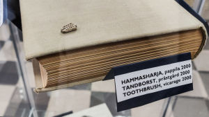 Tandborsten har hittats vid Pernå prästgård. Det är ett viktigt och ganska sällsynt fynd som Museiverket vill ha i sina egna utställningar. Vuokko och Putkonen hoppas på att få låna något annat intressant i stället. Bit av en tandborste i glasmonter.