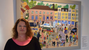 Tf kultursekreterare Sanna Himmelroos framför en tavla av Ekenäskonstnären Ilse Ackermann. Tf. Kultursekreterare i Raseborg Sanna Himmelroos.