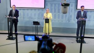 Journalisterna ställde ivrigt frågor till Mika Lintilä (C), Maria Ohisalo (Gröna) och Timo Harakka (SDP) samt de övriga representanterna. Mika Lintilä, Maria Ohisalo och Timo Harakka står vid talarpodium och håller presskonferens.