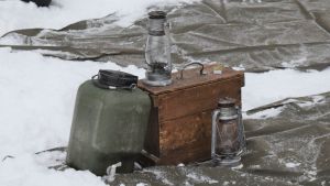 Vattendunk och stormlykta är väsentliga tillbehör för den som övernattar i skogen. Stormlyktor och vattenkanister som behövs för övernattning i skogen.