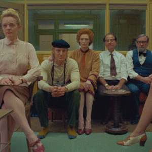 Allvarliga miner på redaktionen, sittande på rad Alumni (Elisabeth Moss), Herbsaint Sazerac (Owen Wilson), J.K.L. Berensen (Tilda Swinton) och två andra som jobbar på redaktionen, skådespelarna Fisher Stevens och Griffin Dunne.