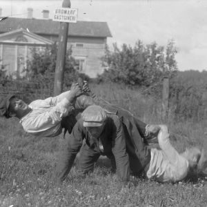 Tre män leker "lyfta saltsäck", där en person är på alla fyra på marken, och de två andra är på hans rygg medan den första försöker stiga upp. Bilden är tagen 1930 i Bromarf.