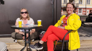 Maria och Mirjami Lappalainen har båda semester. Två kvinnor sitter vid ett bord utomhus.