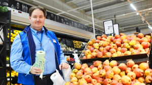 Butikschef Jan Jansson. En medelålders man i blå skjorta håller i en rulle med biopåsar. Han står bredvid en hylla med päron.