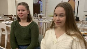- Ungdomar är lata, så det är bra att man åker ut till dem, tycker Mathilda Palmborg och Emilia Ståhl från Jakobstads ungdomsfullmäktige. Två unga kvinnor med långt hår sitter på var sin stol i ett stort rum.