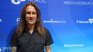 Rik Ferguson anser att det inte är vanliga konsumenters uppgift att skydda sig mot framtidens cyberhot. det är företagens uppgift. En man med långt mörkt hår och ser rakt in i kameran. Han är tatuerad och står framför en blå vägg