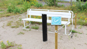 Rökrutan i Hangöby är försedd med bänk, ett rep kring bänken, askkopp och en liten skylt som visar att rökarna ska sitta här. Avskilt område för rökare på strand
