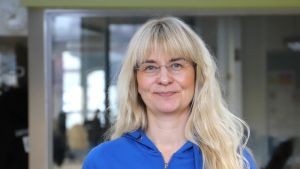 Många gruvar sig för ens vardag och arbete påverkas då man närmar sig övergångsåldern, säger Janina Andersson som själv känner att denna livsfas närmar sig. Hon efterlyser en öppnare debatt om hur klimakteriet påverkar oss. En kvinna med långt ljust hår, glasögon och en klarblå blus.