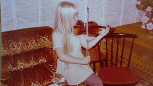 I Raakels barndomshem musicerades det alltid. Gulnat foto av Raakel som övar violin sittandes på soffkanten som liten.
