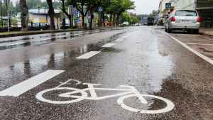 Det har redan kommit in feedback om försöket. De flesta som har gillat det är cyklister. Bild på Ågatan i Borgå. På gatan har man med vitt målat vita linjer och bilder på cyklar på båda sidorna av körbanan.