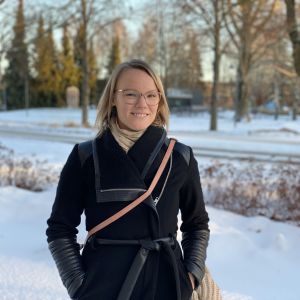 En ljushårig kvinna intill en snöig gata.