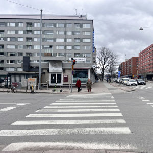 Risteysalue Turun Hämeenkadulla. Kaksi henkilöä ylittää tien.