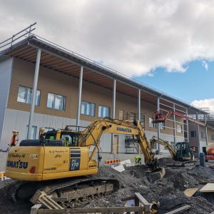 En grävmaskin utanför nybygget av nya skolan i Sjundeå.