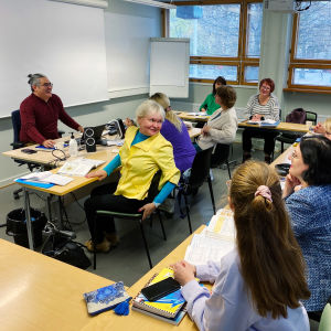 Ukrainare deltar i en lektion i ett klassrum.