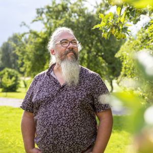 Jyväskylän yliopiston ekologian professori Janne Kotiaho seisoo omenapuun vierellä.
