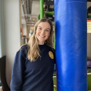 Erica Mäki-Ullakko står bredvid en boxningssäck i ett gym. 
