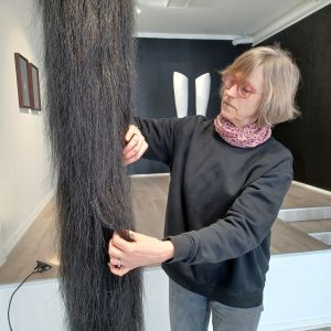 Vasakonstnären Mia Damberg rättar till sin skulptur Hommage to a great horse som ser ut som en överdimensionerad hästsvans