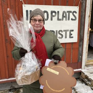 En kvinna med en korg och ett stort pepparkakspris.