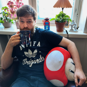 Johannes Ekholm dricker kaffe i en fatölj.