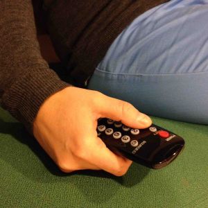 hand som håller i fjärrkontroll