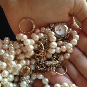 smycken, pärlor, guldringar, armband med mera i en salig röra