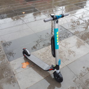 Även privata företag försöker bidra med miljövänliga lösningar i Paris, som denna sparkcykel, som du kan hyra där du är och lämna där du vill. En sparkcykel på en regnig trottoar.
