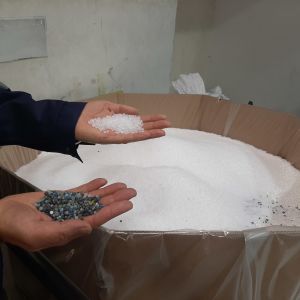 Man håller granulat som används inom plastindustrin.