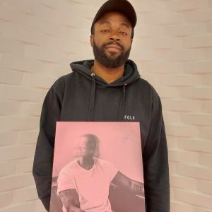 Folk var albumnet som slungade iväg Jesse Markin mot den finländska stjärnhimmeln. Markin med sitt album Folk i famnen. Ser in i kameran. keps och tegelvägg i bakgrunden.