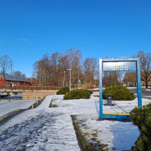 En ram där man kan fotografera sig i Ingå kyrkby med hamnen eller kyrkan i bakgrunden.