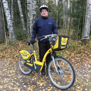 Antti Oramo seisoo syksyisessä maisemassa kapunkipyörän kanssa.