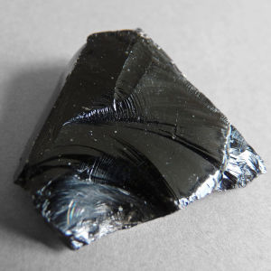 Obsidian från ön Lipari norr om Sicilien. Närbild av bergarten obsidian.