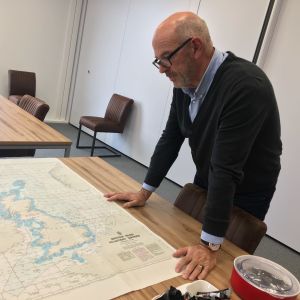Johan K. Nooitgedagt visar en karta över Storbritanniens exklusiva ekonomiska zon. Ordföranden för det holländska fiskarförbundet böjer sig över en karta över Storbritannien i sitt arbetsrum.