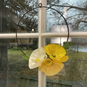 Käsintehty kukkakranssi ikkunassa